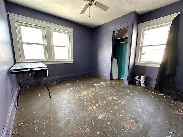 unfurnished bedroom featuring a textured ceiling, a closet, multiple windows, and ceiling fan