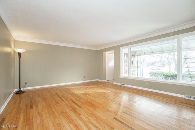 empty room featuring light wood-type flooring and crown molding