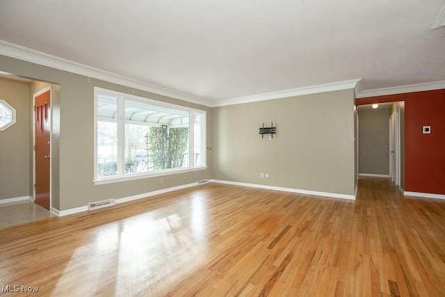 spare room featuring light wood-type flooring and crown molding