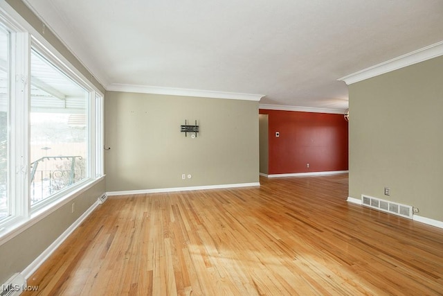 empty room featuring hardwood / wood-style flooring, ornamental molding, and a baseboard radiator