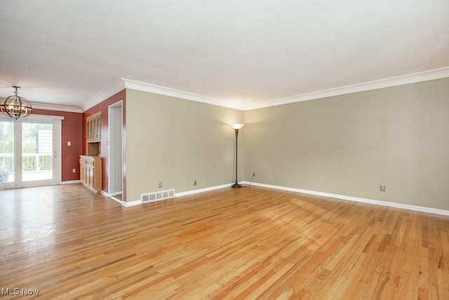 unfurnished room featuring a chandelier, light hardwood / wood-style floors, and ornamental molding