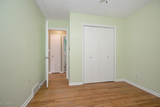 unfurnished bedroom with a closet and light hardwood / wood-style floors