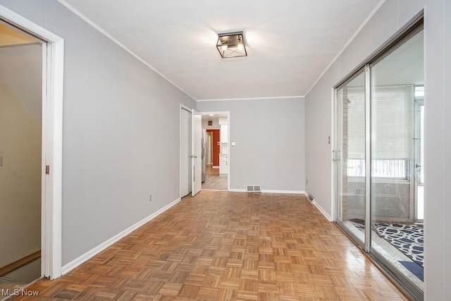 empty room featuring crown molding and light parquet floors