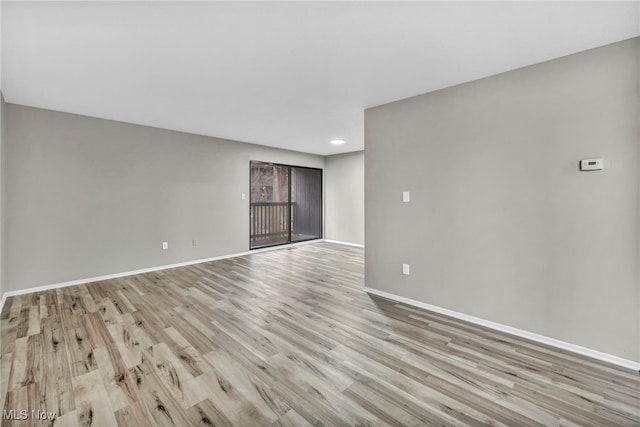 spare room featuring wood finished floors and baseboards