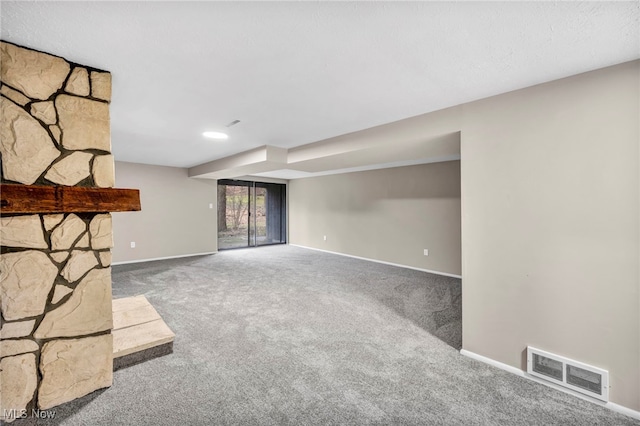 unfurnished living room featuring baseboards, visible vents, and carpet floors