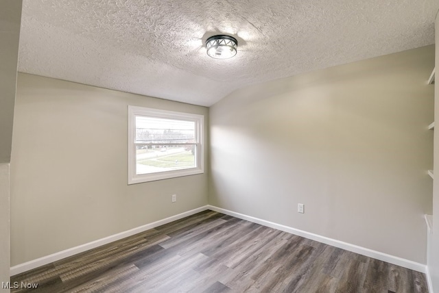 unfurnished room with a textured ceiling, hardwood / wood-style flooring, and lofted ceiling