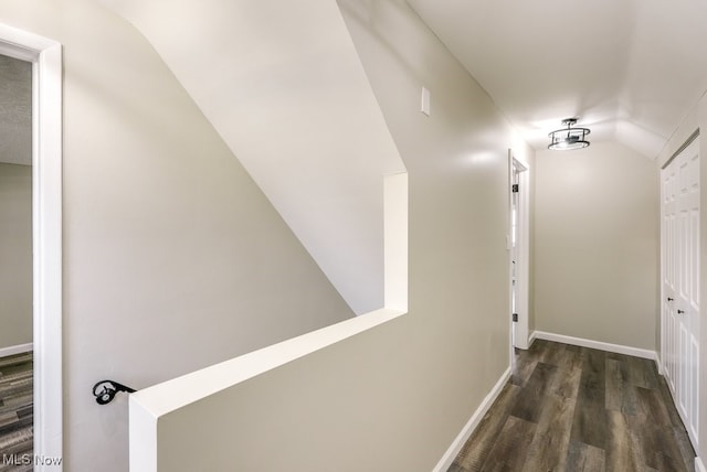 hall with dark wood-type flooring and vaulted ceiling