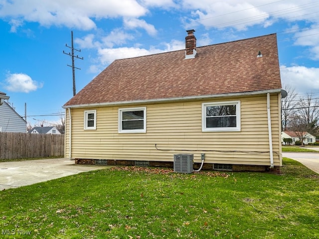 rear view of property with a lawn, cooling unit, and a patio