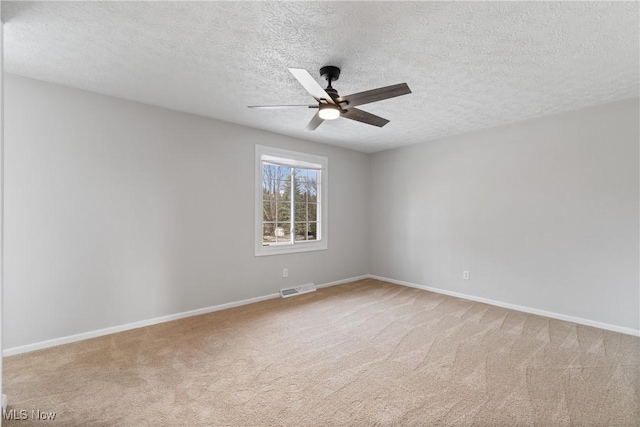 carpeted empty room with ceiling fan and a textured ceiling