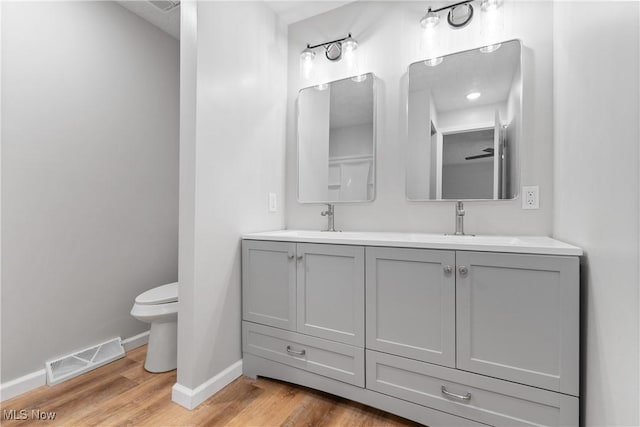 bathroom featuring hardwood / wood-style flooring, vanity, and toilet