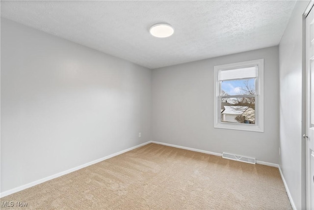 carpeted spare room featuring a textured ceiling