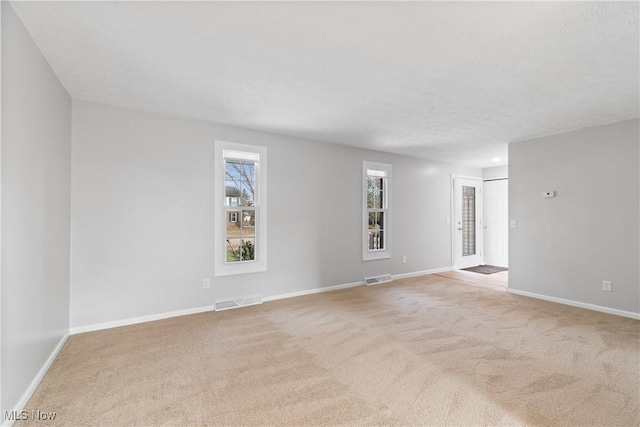 spare room featuring light colored carpet