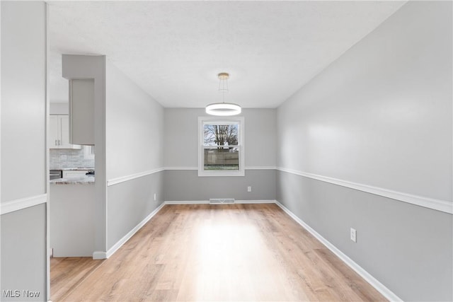 unfurnished dining area with light wood-type flooring