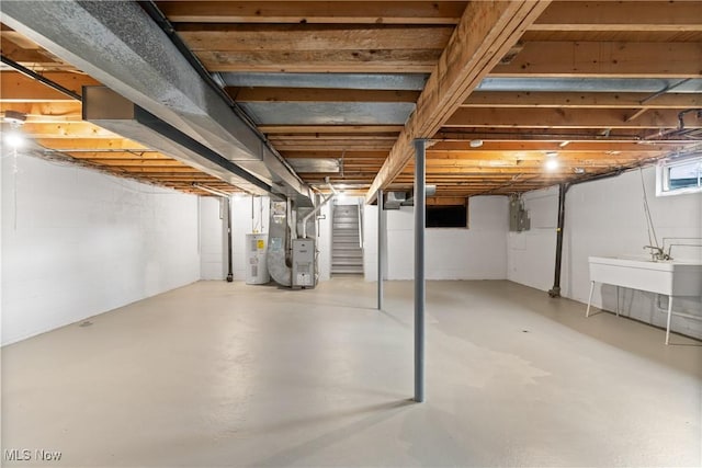 basement featuring sink, electric water heater, heating unit, and electric panel