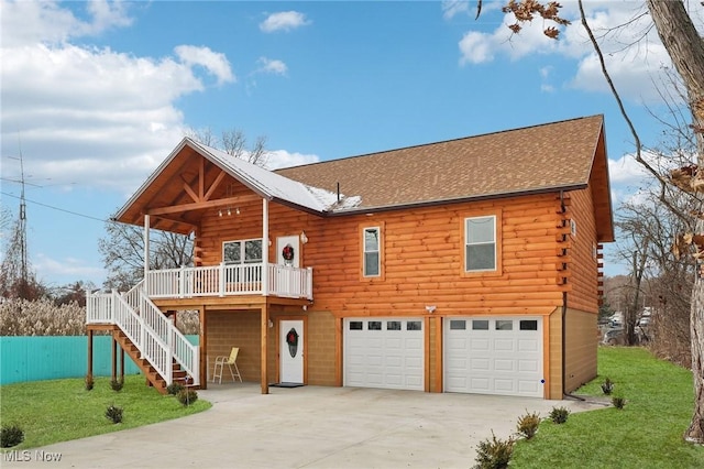 cabin featuring a front yard and a garage