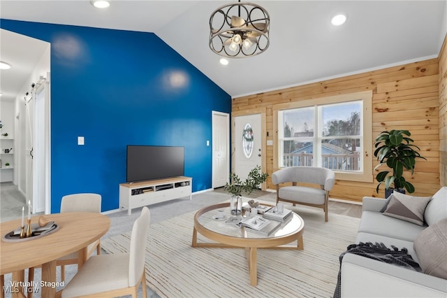 living room featuring light colored carpet, lofted ceiling, a chandelier, and wood walls