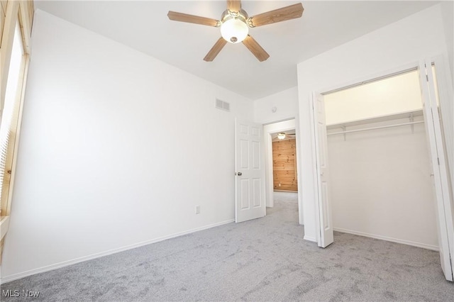 unfurnished bedroom featuring light colored carpet, a closet, and ceiling fan