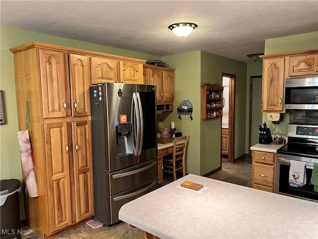 kitchen with stainless steel appliances and a textured ceiling