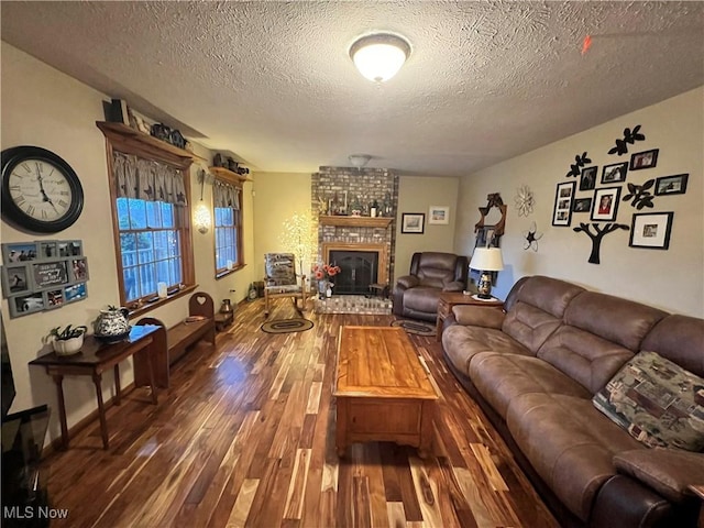 living room with a fireplace, a textured ceiling, and dark wood-type flooring