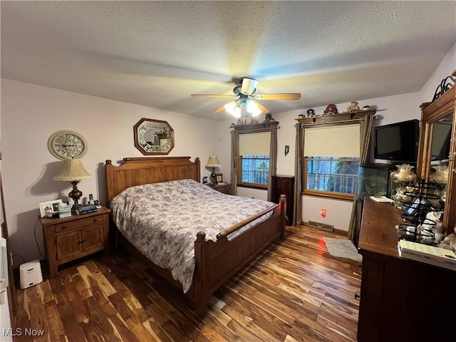 bedroom featuring a textured ceiling, ceiling fan, and dark wood-type flooring