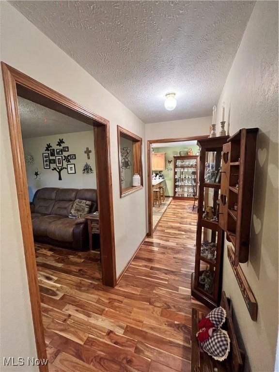 hall featuring hardwood / wood-style floors and a textured ceiling