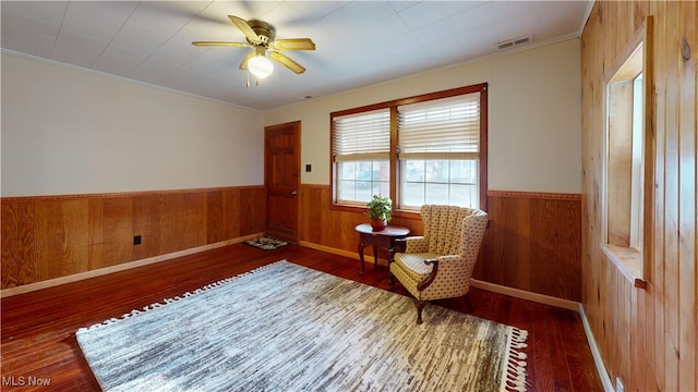 living area featuring ceiling fan and dark wood-type flooring
