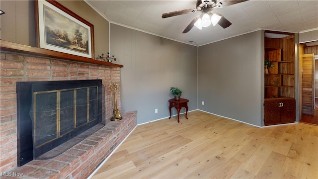 unfurnished living room featuring hardwood / wood-style floors, a brick fireplace, ceiling fan, and ornamental molding