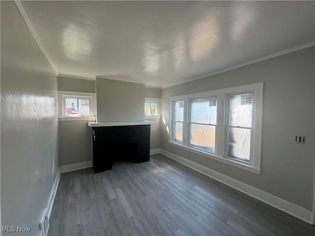 empty room featuring ornamental molding, dark wood-type flooring, and a brick fireplace