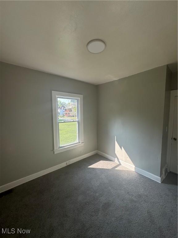 empty room featuring dark colored carpet