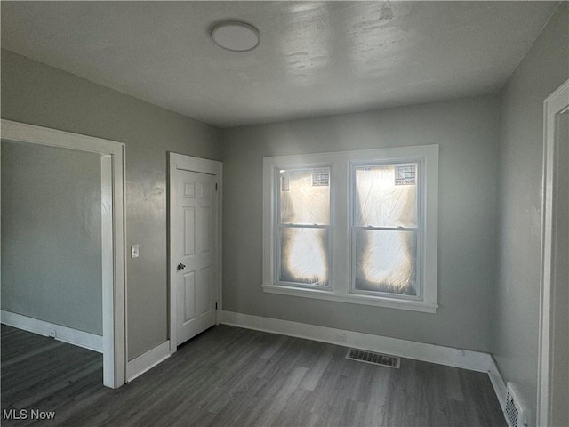 unfurnished bedroom featuring dark hardwood / wood-style flooring