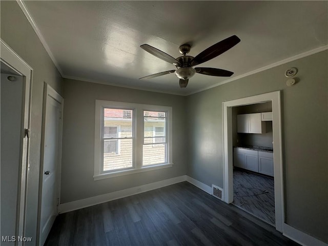 unfurnished bedroom featuring dark hardwood / wood-style flooring, ceiling fan, and ornamental molding