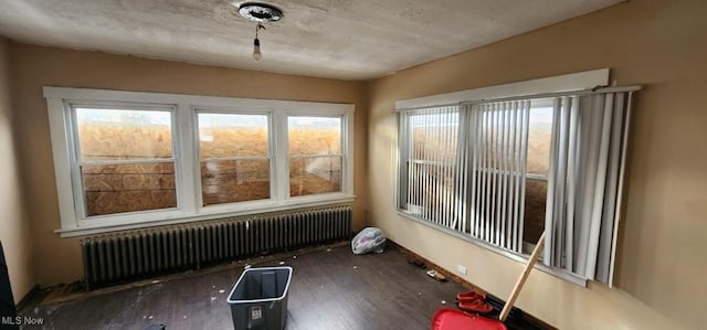 unfurnished sunroom with radiator heating unit