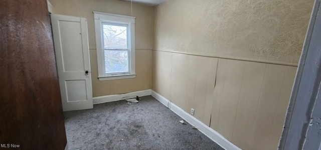 unfurnished room featuring wood walls