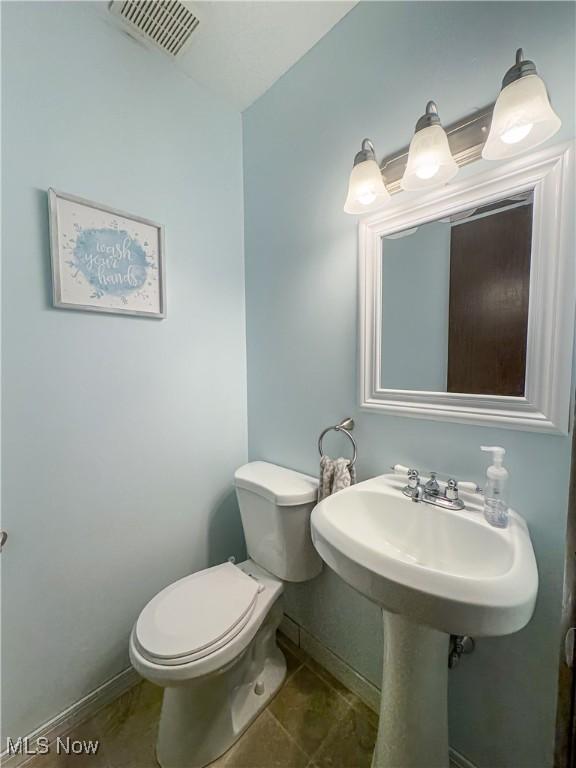 bathroom with tile patterned floors and toilet