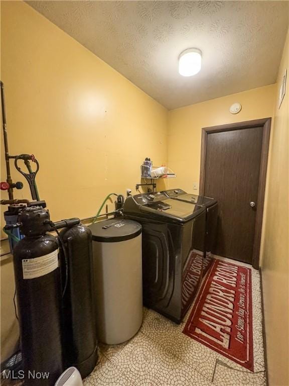 washroom featuring washer and dryer and a textured ceiling