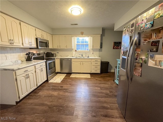 kitchen with dark hardwood / wood-style flooring, sink, white cabinets, and stainless steel appliances