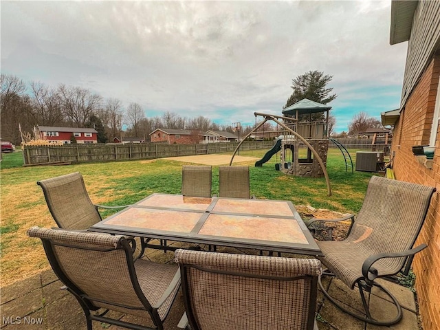 view of patio featuring a playground and central air condition unit