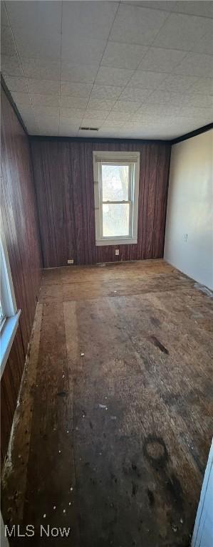 unfurnished room featuring wood walls