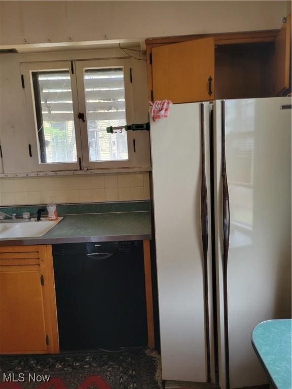 kitchen with dishwasher, sink, backsplash, and stainless steel refrigerator