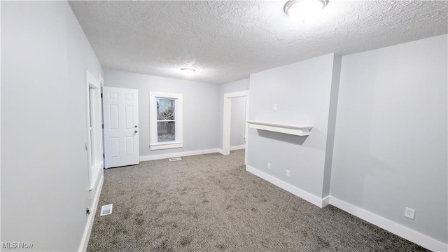 spare room with carpet and a textured ceiling