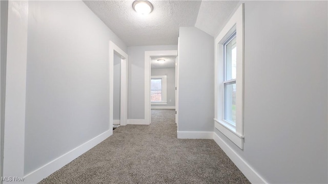 corridor featuring carpet flooring and a textured ceiling