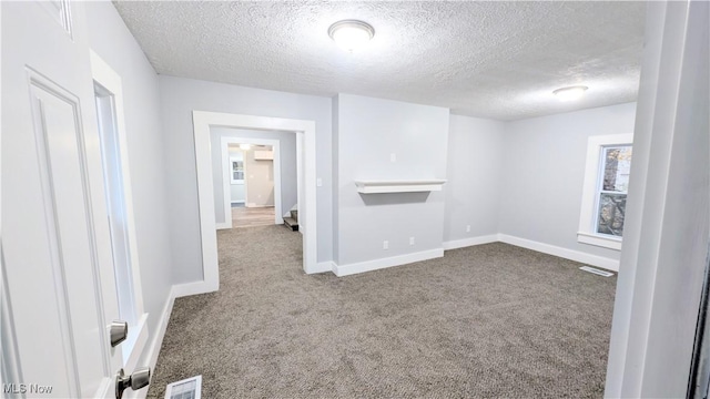 empty room featuring carpet and a textured ceiling