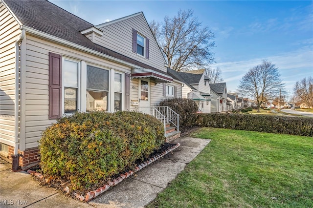 view of side of home with a yard