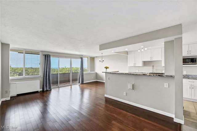 kitchen featuring dark stone countertops, plenty of natural light, and white cabinets