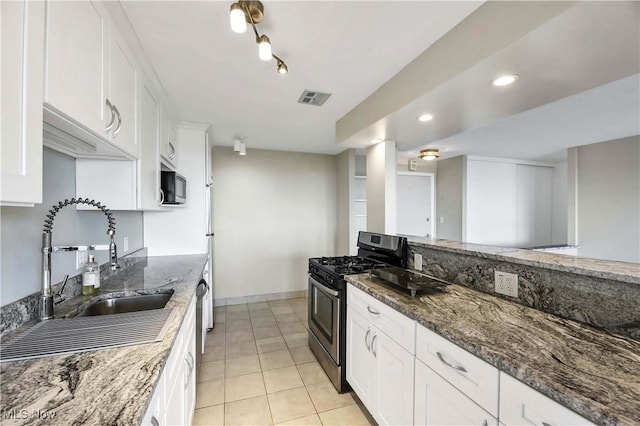 kitchen featuring white cabinets, sink, stainless steel appliances, and dark stone countertops