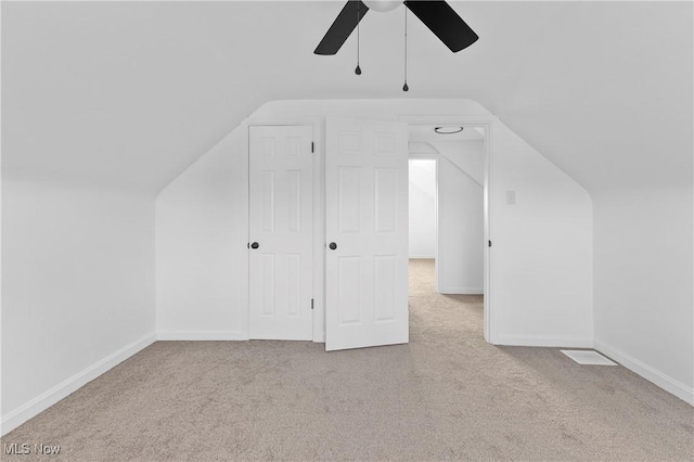 additional living space featuring ceiling fan, light carpet, and vaulted ceiling