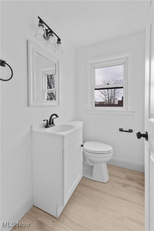 bathroom with vanity, hardwood / wood-style flooring, and toilet