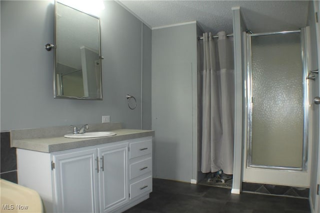 bathroom featuring vanity, an enclosed shower, and a textured ceiling