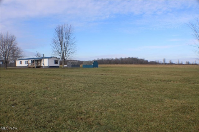 view of yard featuring a rural view and an outdoor structure