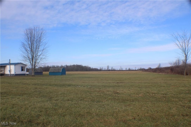 view of yard with a rural view and a shed